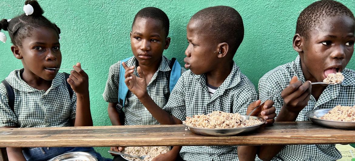 Children in Haiti eat a meal provided as part of WFP’s school feeding programme.